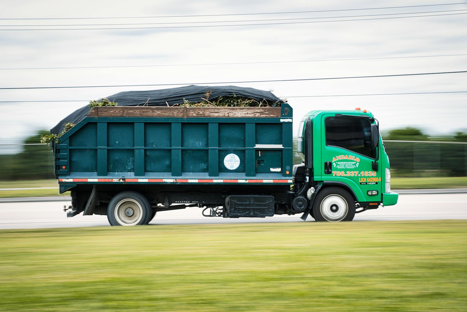 Chip truck loaded with brush from a Tomball tree-removal job, ready to haul off.